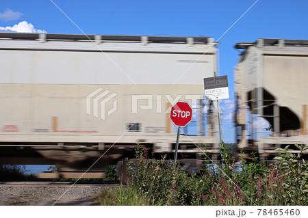A train speeds past a stop sign at a crossing 78465460