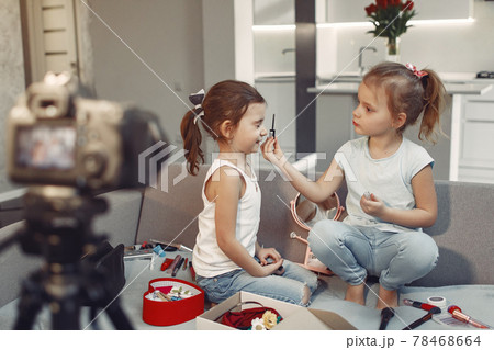 Cute little blogger with cosmetics recording video at home 78468664