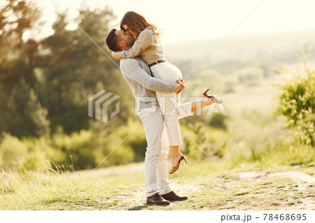 Beautiful couple spend time on a summer field Beautiful couple spend time on a summer field 78468695