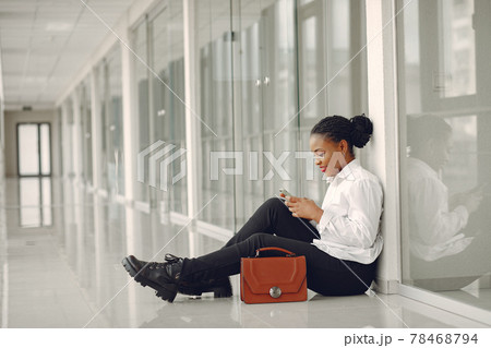 Black woman standing in the office with a laptop 78468794