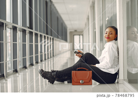 Black woman standing in the office with a laptop 78468795
