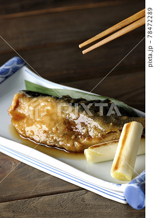 笹の葉が敷いてあるブリの照り焼きと焼き葱を食べる 78472289