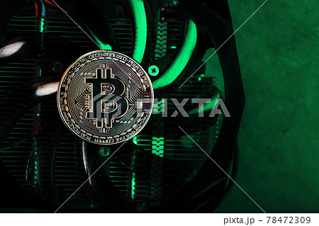 Gold bitcoin on the video card cooler with green neon lighting in the Cyberpunk style. 78472309