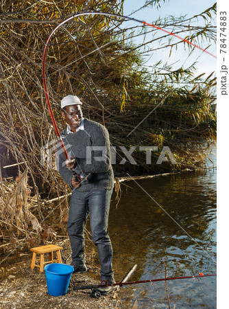 Man and pulling fish near river Man and pulling fish near river 78474883