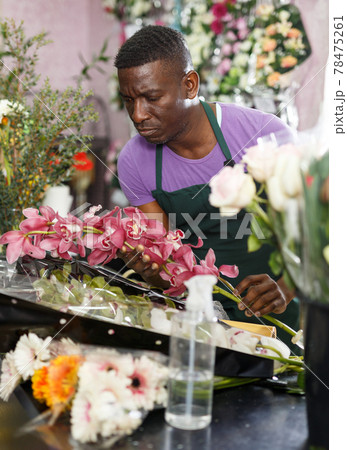 Florist preparing orchids for bouquet 78475261