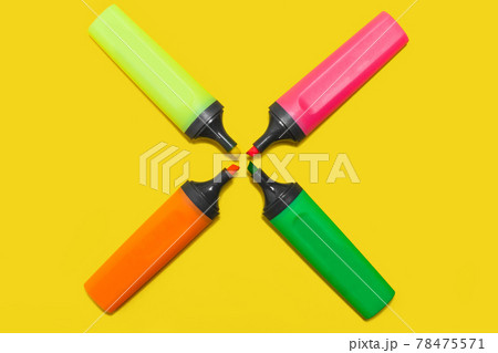 four office plastic markers on a yellow surface 78475571