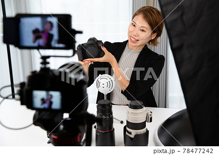一眼レフカメラで動画を撮影する女性 78477242