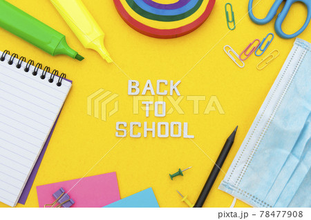 Back to school words. Face mask, colorful pencils, rainbow eraser, notebook, sticky notes and office supplies. Flat lay. Abstract educational background. 78477908