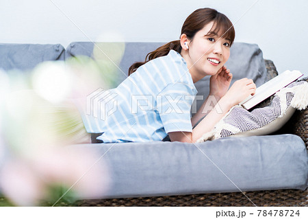 ソファで寝転んで読書する女性 78478724