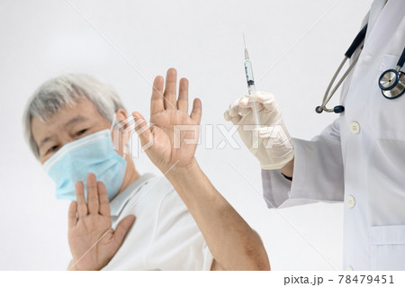 Doctor prepares to vaccinate,old senior refusing to receive a Coronavirus vaccine,uneasiness of elderly about medication quality or side effects after vaccination,insecure,distrust of COVID-19 vaccine 78479451