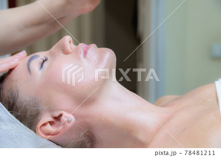 The girl is given a face and neck massage in a beauty salon. The girl is given a face and neck massage in a beauty salon. 78481211