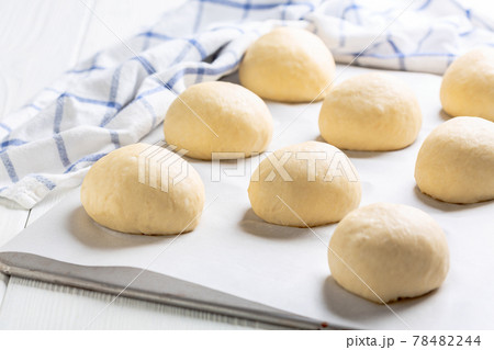Wheat buns rising on a baking sheet. Wheat buns rising on a baking sheet. 78482244