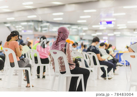 Muslim woman with hijab wait in a queue to receive covid-19 vaccine. 78483004