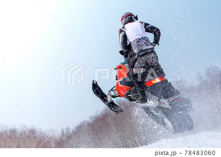 Snowmobile in high jump above track. Selective focus Snowmobile in high jump above track. Selective focus 78483060