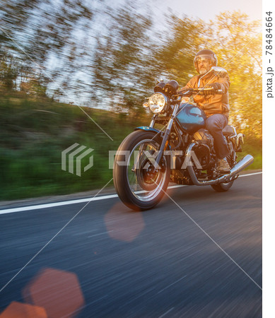 Motorcycle driver riding in Alpine landscape. Motorcycle driver riding in Alpine landscape. 78484664