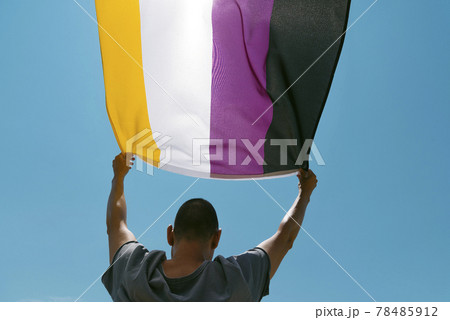 person waving a non-binary pride flag person waving a non-binary pride flag 78485912