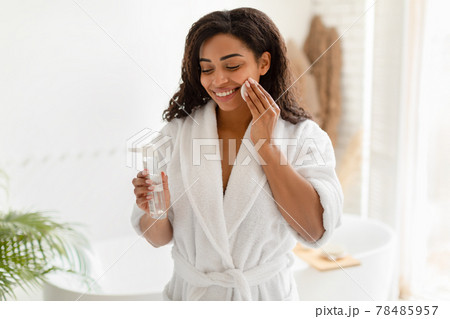 Black Female Using Cotton Pad And Micellar Water In Bathroom Black Female Using Cotton Pad And Micellar Water In Bathroom 78485957