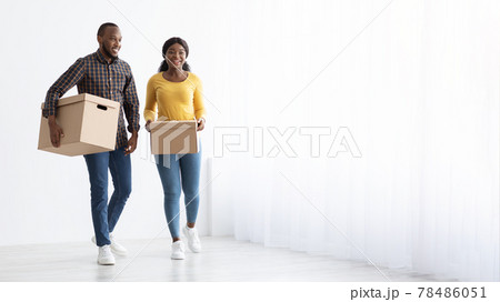 Relocation Concept. Young African American Spouses Walking With Cardboard Boxes Near Window 78486051