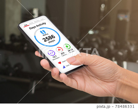 Unrecognizable woman checking daily activity while exercising at gym 78486331