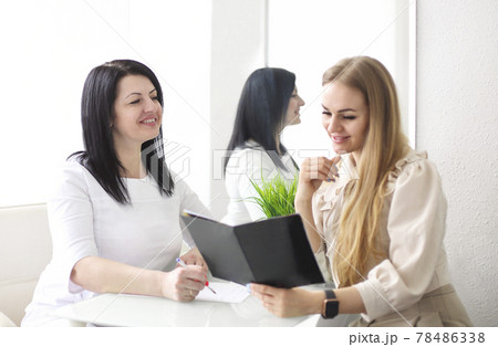 Smiling woman talking to beautician in salon Smiling woman talking to beautician in salon 78486338