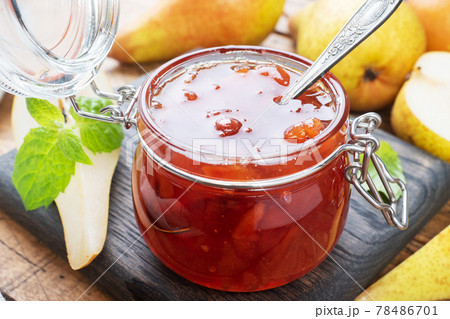 Homemade pear jam in a jar and fresh pears on a wooden background. 78486701