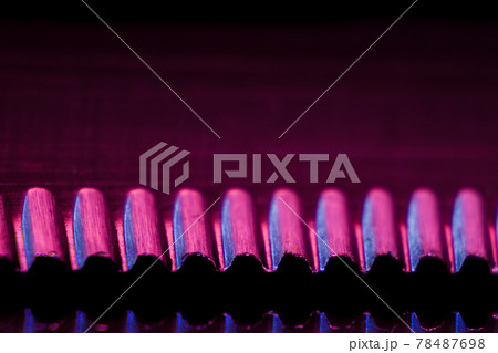 Edge of an illuminated  serrated knife and their reflection macro shot suitable as a background. 78487698