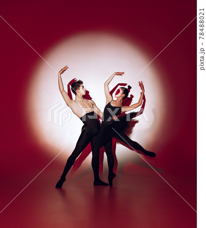 Ballet dancers dancing over red studio background. Modern design. Contemporary colorful conceptual light as rising sun at Japan. Ballet dancers dancing over red studio background. Modern design. Contemporary colorful conceptual light as rising sun at Japan. 78488021
