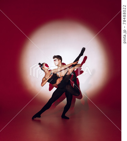Ballet dancers dancing over red studio background. Modern design. Contemporary colorful conceptual light as rising sun at Japan. Ballet dancers dancing over red studio background. Modern design. Contemporary colorful conceptual light as rising sun at Japan. 78488022