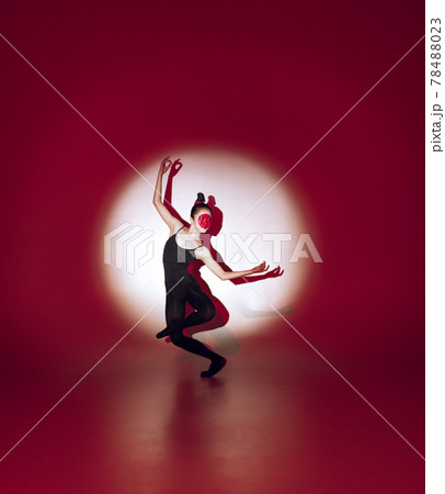 Ballet dancer dancing over red studio background. Modern design. Contemporary colorful conceptual light as rising sun at Japan. Ballet dancer dancing over red studio background. Modern design. Contemporary colorful conceptual light as rising sun at Japan. 78488023