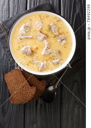 Artsoppa is a Swedish soup that is predominantly yellow split peas and meat close up in the plate. Vertical top view 78492299