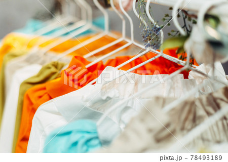 Light craft vintage summer dresses hanging on hangers in the store 78493189