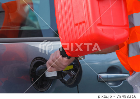 Driver fills the fuel in an empty car tank from canister. Driver fills the fuel in an empty car tank from canister. 78493216
