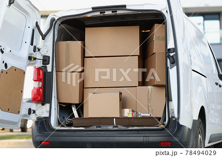 Lot of cardboard boxes are in minivan with open door closeup Lot of cardboard boxes are in minivan with open door closeup 78494029