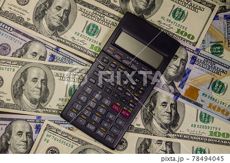 Calculator on the American one hundred dollar bills background Calculator on the American one hundred dollar bills background 78494045