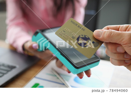 Man applying credit bank card to pos terminal closeup 78494060