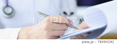 Hands of doctor holding clipboard and writing down examination results with pen Hands of doctor holding clipboard and writing down examination results with pen 78494282