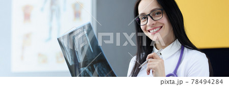 Portrait of smiling medical doctor woman holding X-ray picture Portrait of smiling medical doctor woman holding X-ray picture 78494284