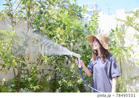 テラスで水やりをする女性 78495531