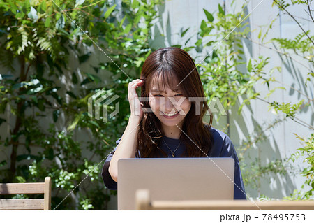テラスのテーブルでPC作業をする女性 テラスのテーブルでPC作業をする女性 78495753