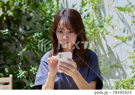 テラスのテーブルでスマホを見る女性 テラスのテーブルでスマホを見る女性 78495924