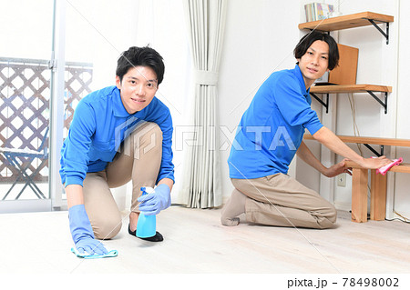 部屋で掃除をする清掃業の作業服の複数の若い男性 78498002