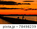 太陽が沈む夕景と遠景の釣り人 78498239