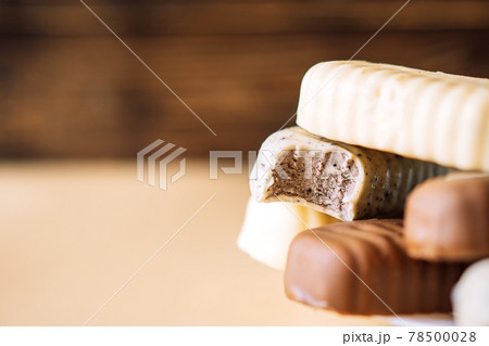 Still life of chocolate popsicle lying on a plate on a wooden background table. Copy space 78500028