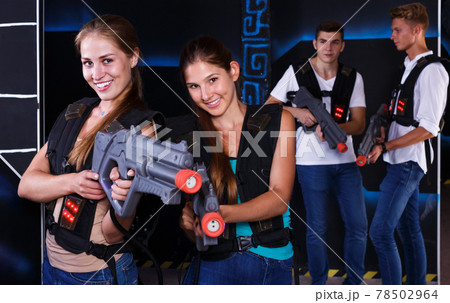 Two girls posing with laser guns 78502964