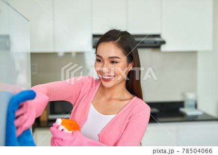 Young asian woman cleaning the kitchen with detergent spray. Young asian woman cleaning the kitchen with detergent spray. 78504066
