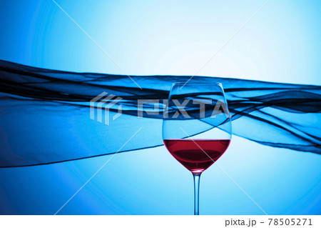Glass of red wine on a background of waving curtain. Glass of red wine on a background of waving curtain. 78505271
