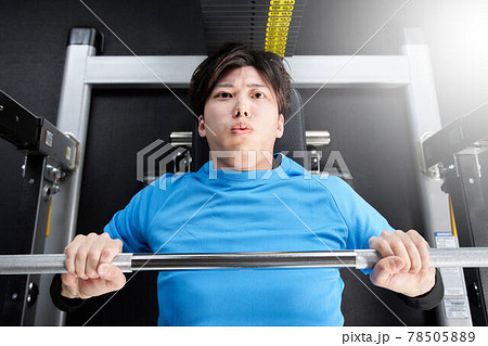 マシンでウエイトトレーニングをする若い男性 78505889