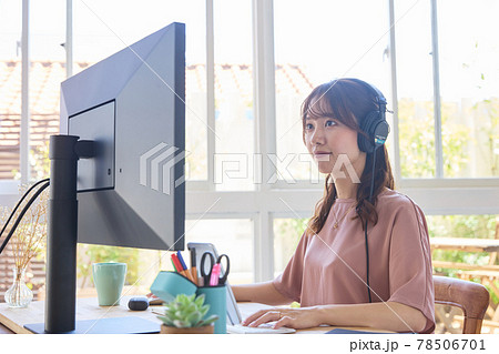 ヘッドフォンでPC作業をする女性 78506701