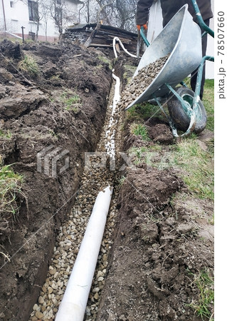 In the yard, workers carry out drainage works for draining water. 78507660