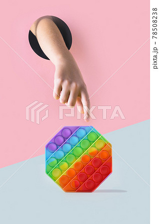 Childs hand through hole in pink paper reaches for green apple on yellow.Food concept. 78508238